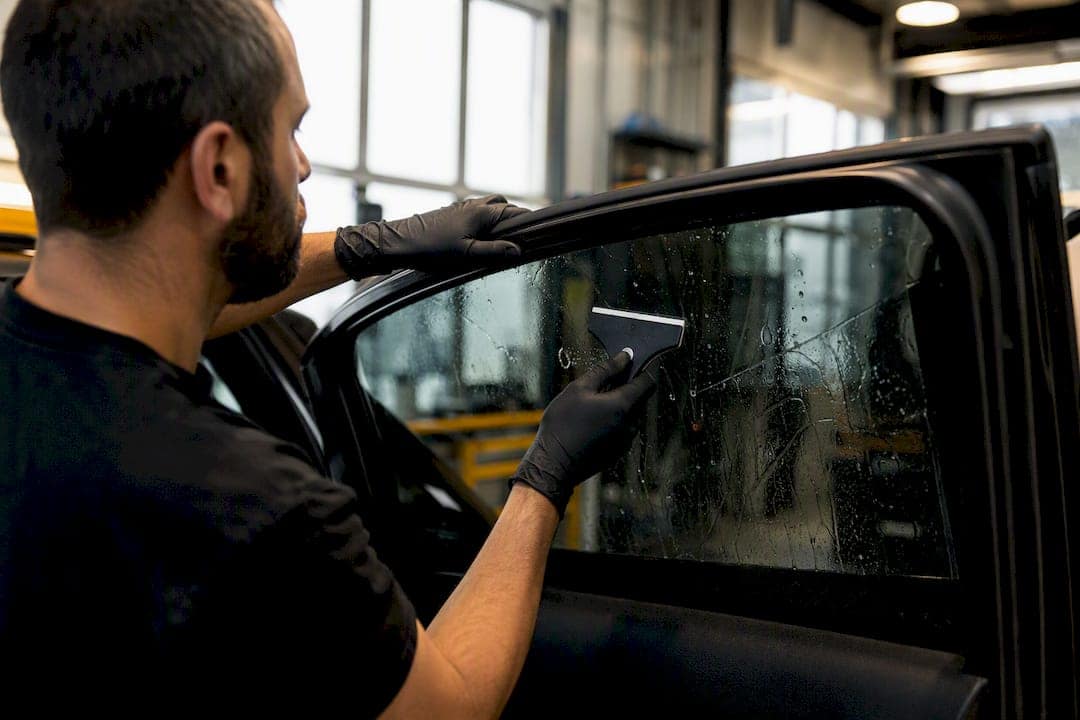 Technician applying window tint film