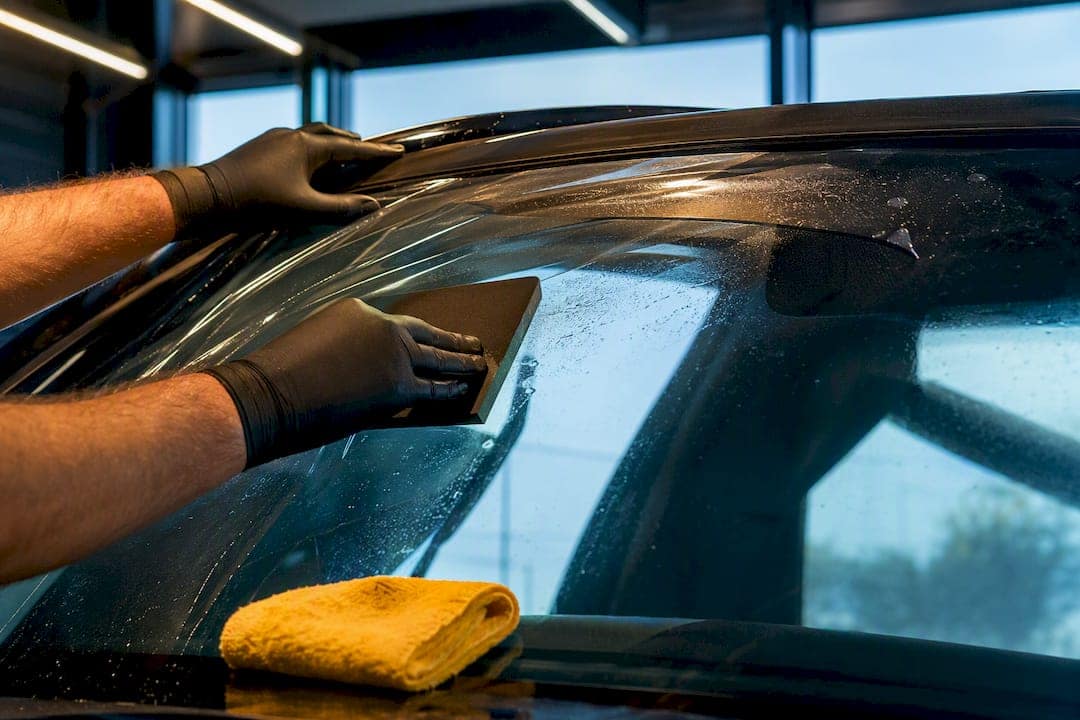 Technician applying windshield protection film