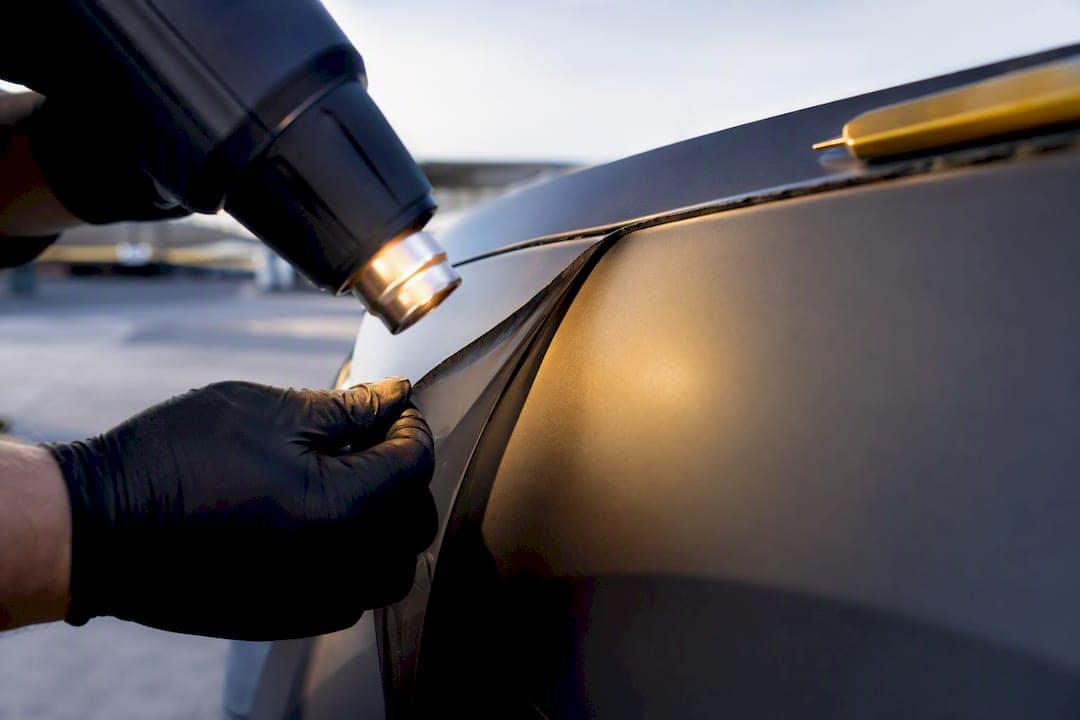 Technician lifting warmed vinyl wrap edge