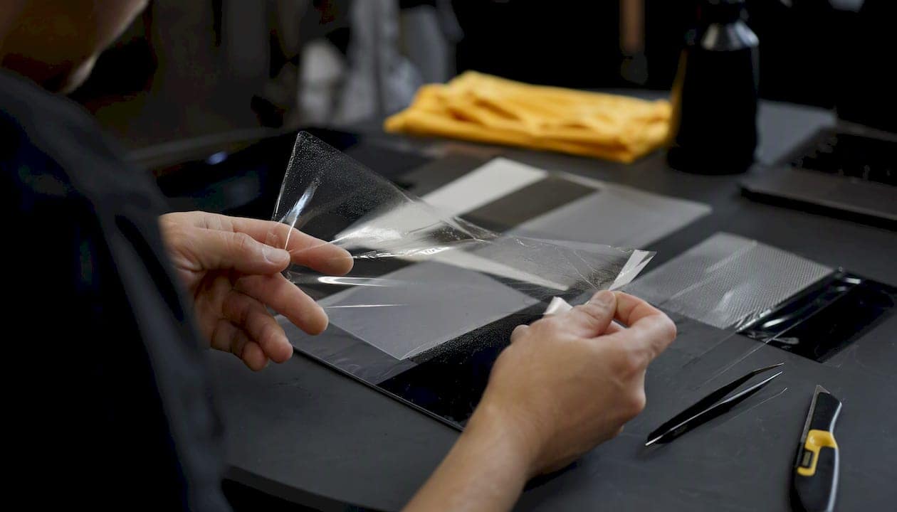 Hands inspecting paint protection film closely