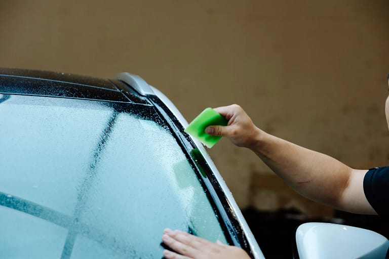 Installer fitting protection film to a windshield