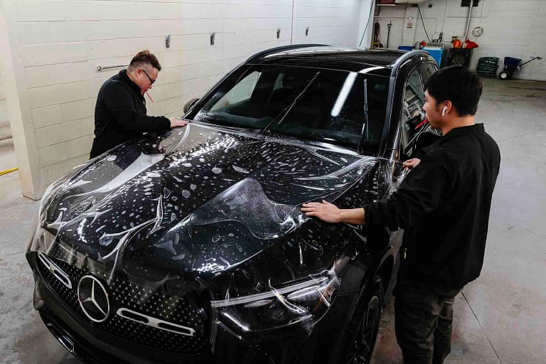 Technicians installing paint protection film at The PPF Company Calgary