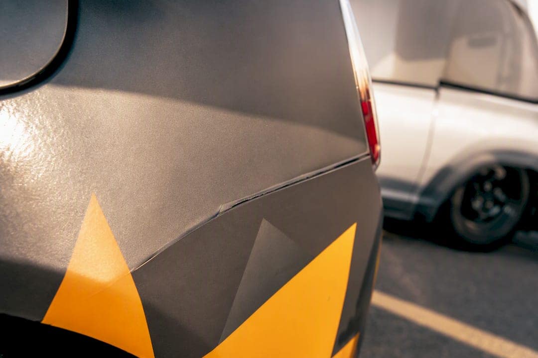Close-up of vinyl wrap edge showing early lift damage